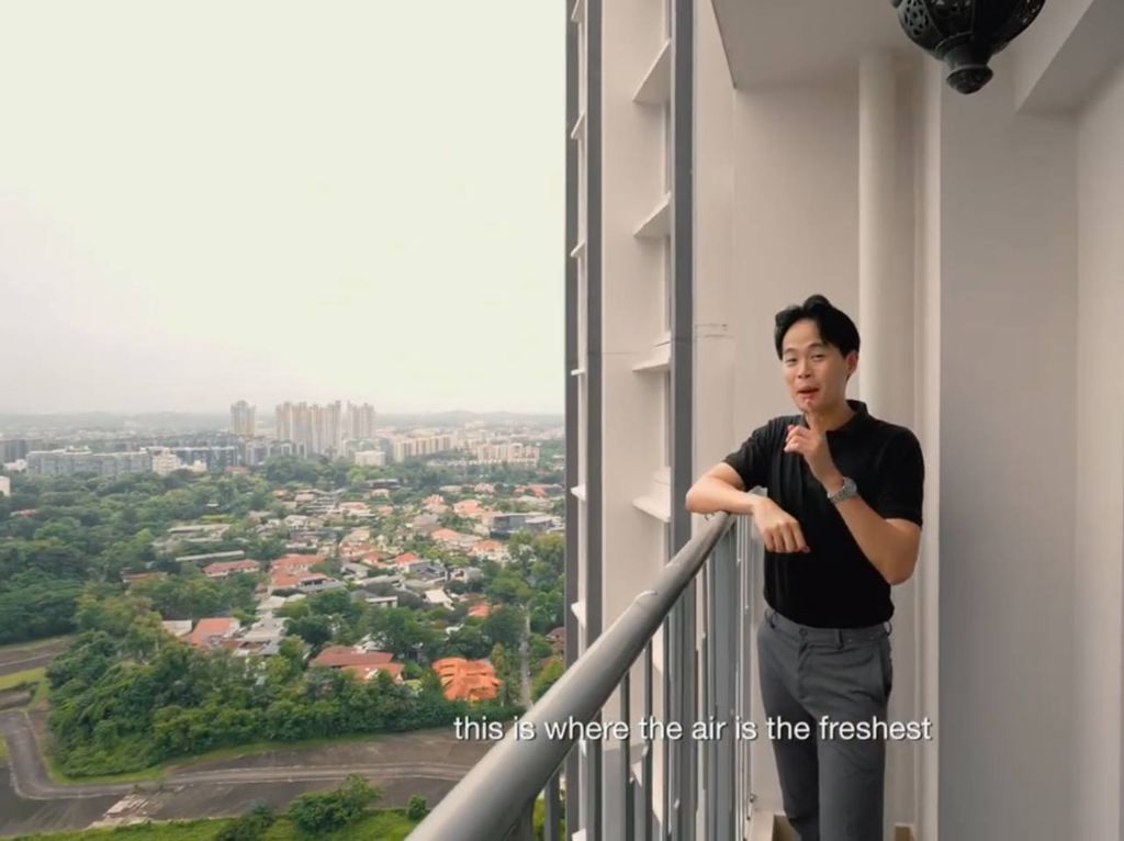 Zack Wong on the balcony of the Margaret Drive 3-room flat, overlooking landed rooftops and greenery